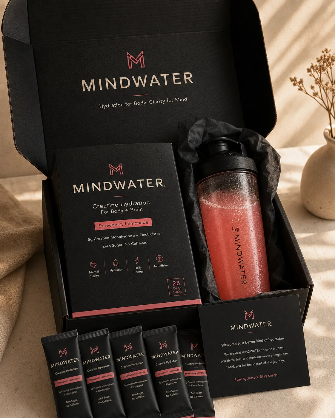 Open premium shipping box revealing the MINDWATER product box, premium shaker wrapped in tissue, welcome card, and daily packs